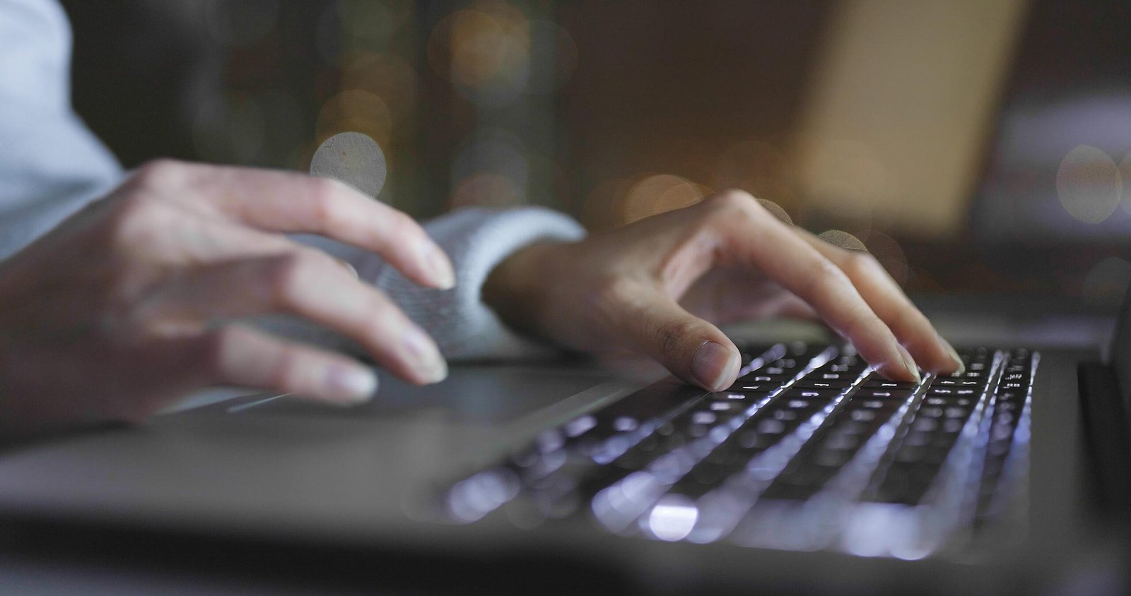 Manos escribiendo en un teclado en un fondo oscuro, representando precios de SEO en Querétaro con estrategias personalizadas para empresas