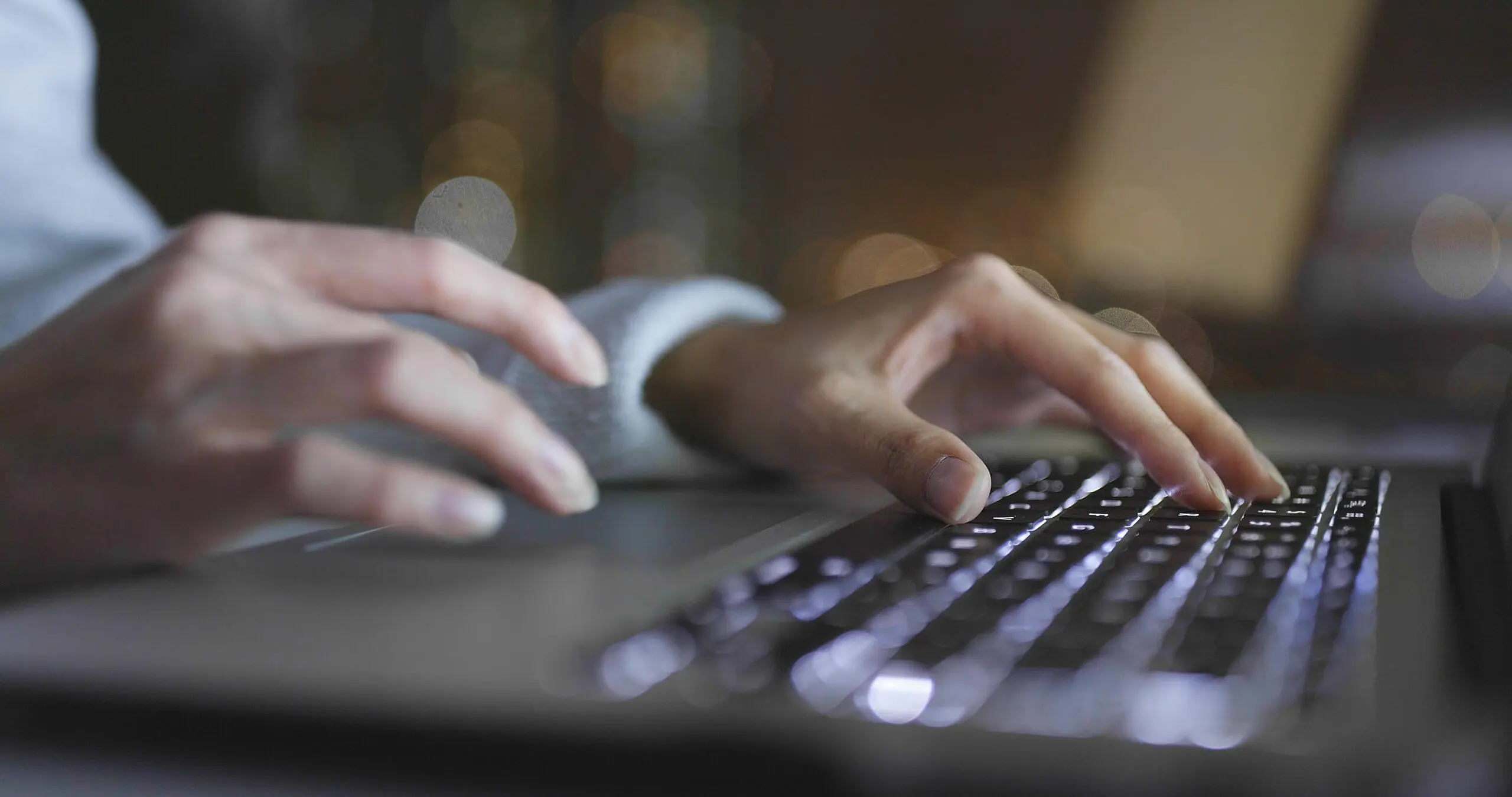 Manos escribiendo en un teclado en un fondo oscuro, representando precios de SEO en Querétaro con estrategias personalizadas para empresas