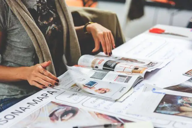 Personas revisando revistas y recortes como referencia visual para un proyecto de branding